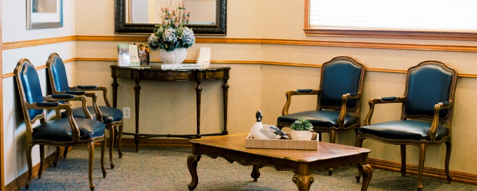 A dentist's waiting room in New Braunfels with several chairs and a table.